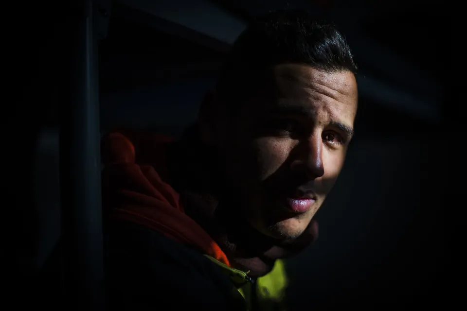 A Moroccan refugee, stranded for two months, in low light